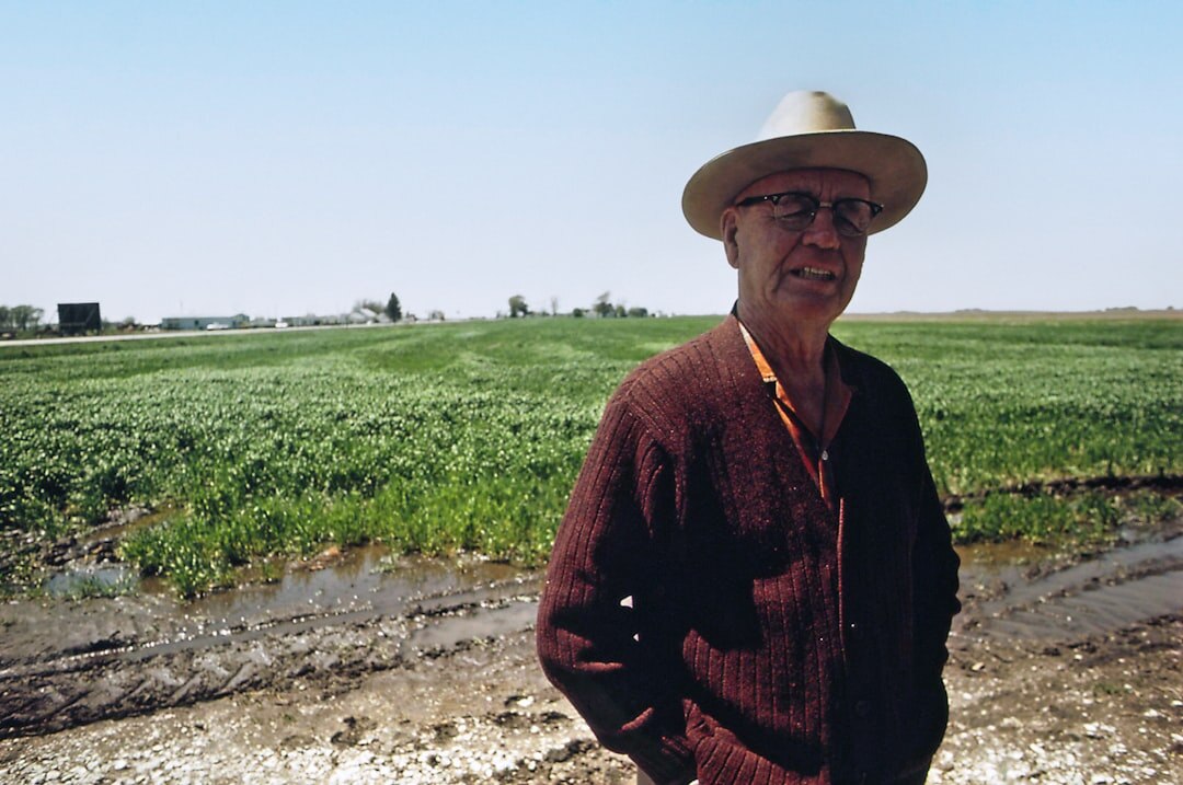 Portrait of an elderly Danish farmer standing in a field